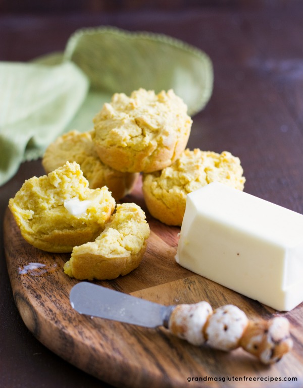 Gluten Free Cornbread muffins on a cutting board with a stick of butter.