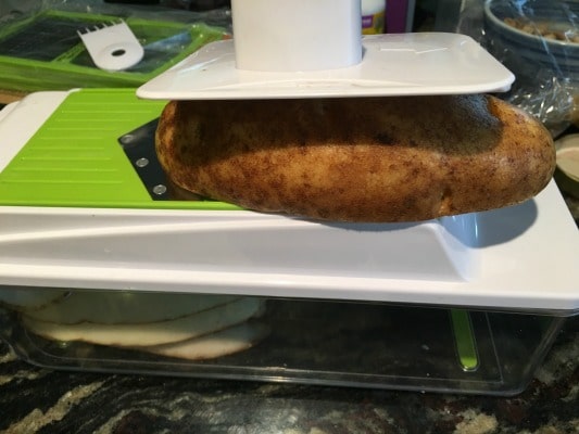 slicing potatoes with a mandolin slicer