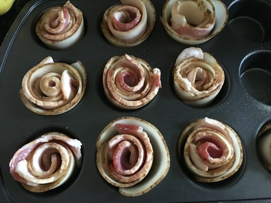bacon roses ready to bake in a muffin tin