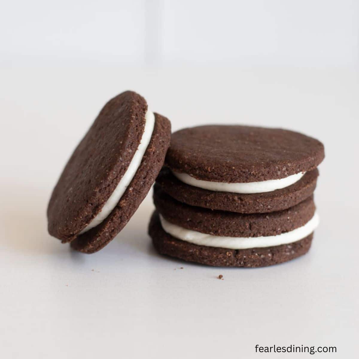 A close up of three gluten-free sandwich cookies on a counter.