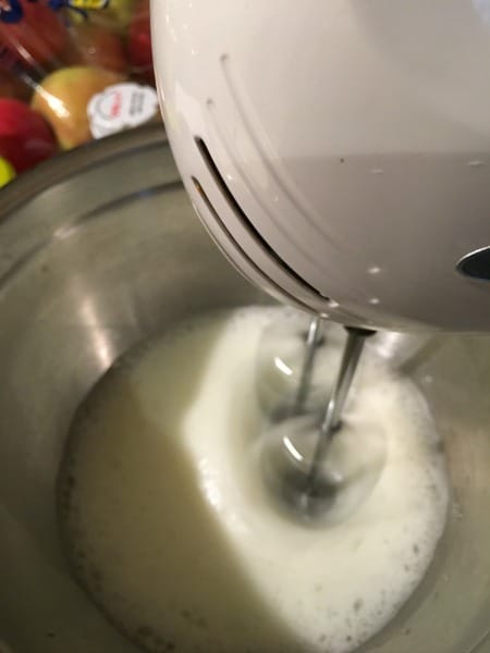 Whipping egg whites with an electric mixer.