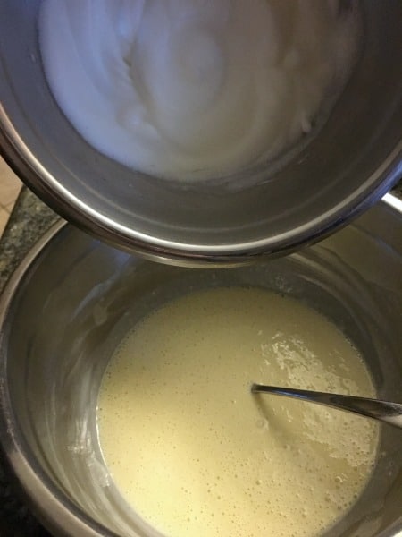 Pouring the whipped stiff egg whites into the lemon cake batter.