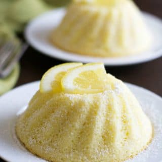 Two gluten free lemon yogurt cakes on small white plates.
