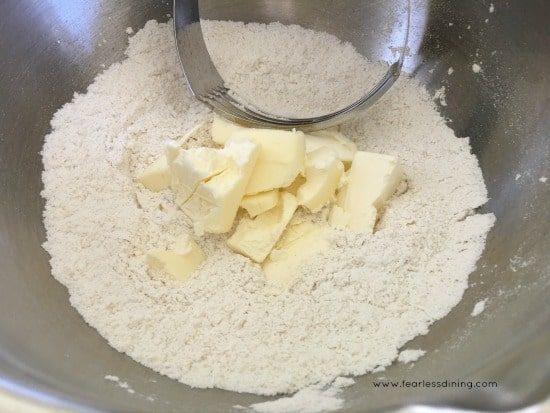 Cutting butter into the dry ingredients with a pastry blender.