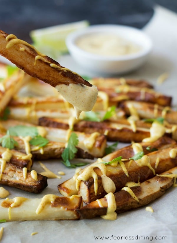 Close up of a French fry dipped in the curry sauce.