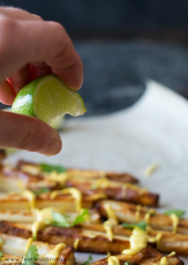 Squeezing a fresh lime over the baked oven fries.