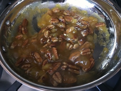Mango jam and pecans cooking in a pan.