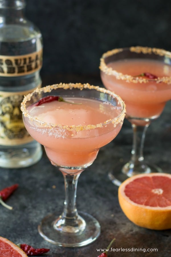 Two margarita glasses filled with pink margarita.