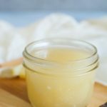 a jar of homemade vanilla sauce on a wooden tray