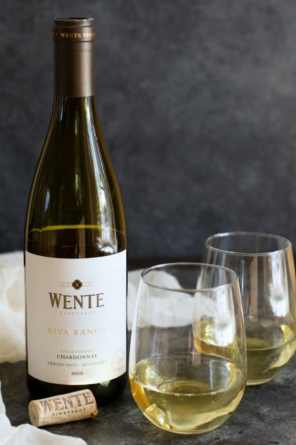 A bottle of Wente Riva Ranch Chardonnay with two wine glasses full of wine.