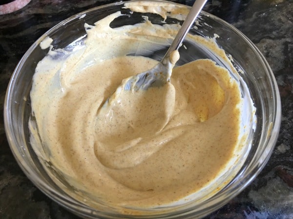 Blended curry dipping sauce in a bowl with a spoon in it.