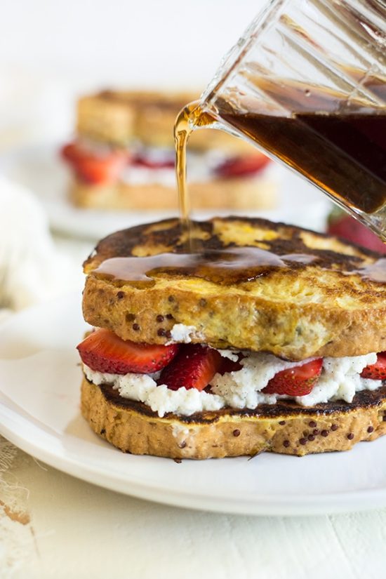 Pouring syrup over gluten free ricotta strawberry stuffed French toast