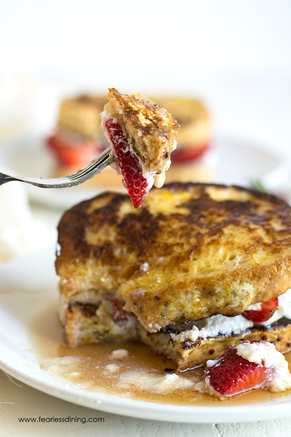 A fork holding up a bite of the stuffed French toast.