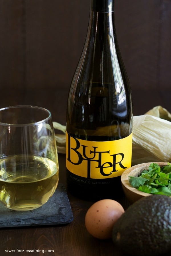 A bottle of JaM Cellars Butter Chardonnay with a wine glass and recipe ingredients.