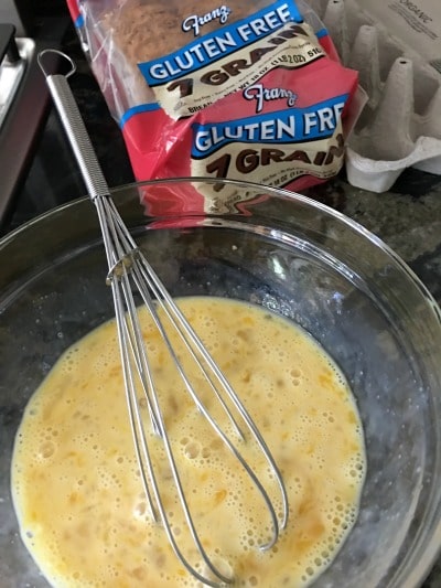 A bowl of whisked eggs with Franz gluten free bread.