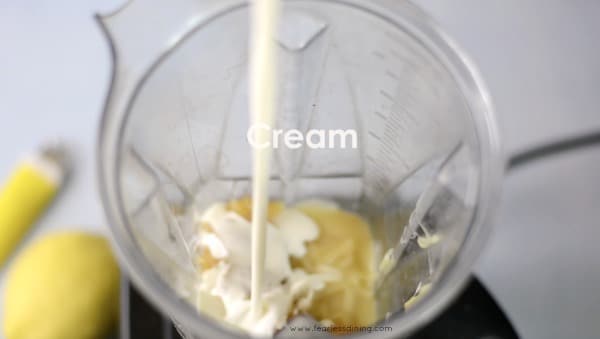 A photo showing adding the heavy  cream into the Vitamix.