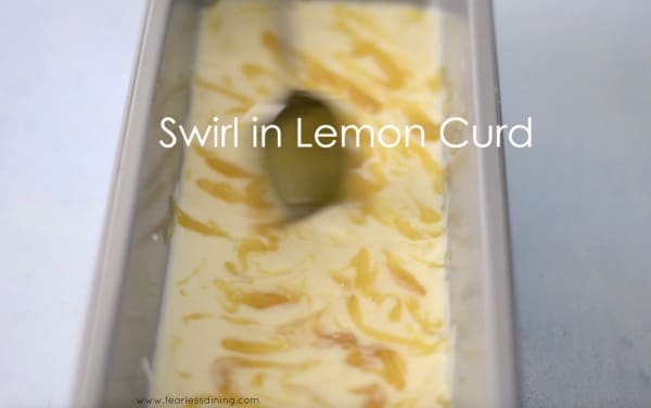 Using a large spoon to swirl in lemon curd.