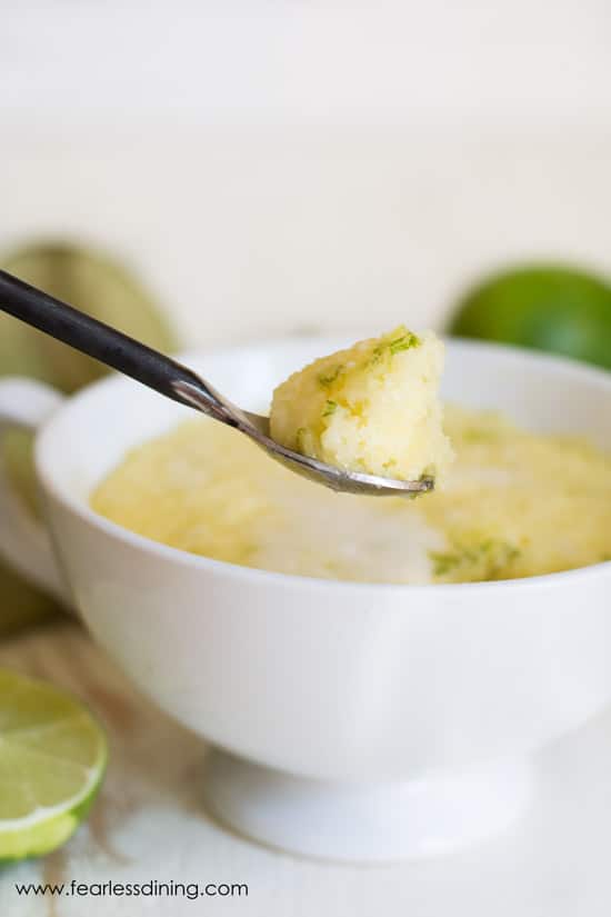 A spoon holding up a bite of lime gluten free mug cake.