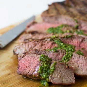 sliced NY strip steak topped with basil garlic sauce