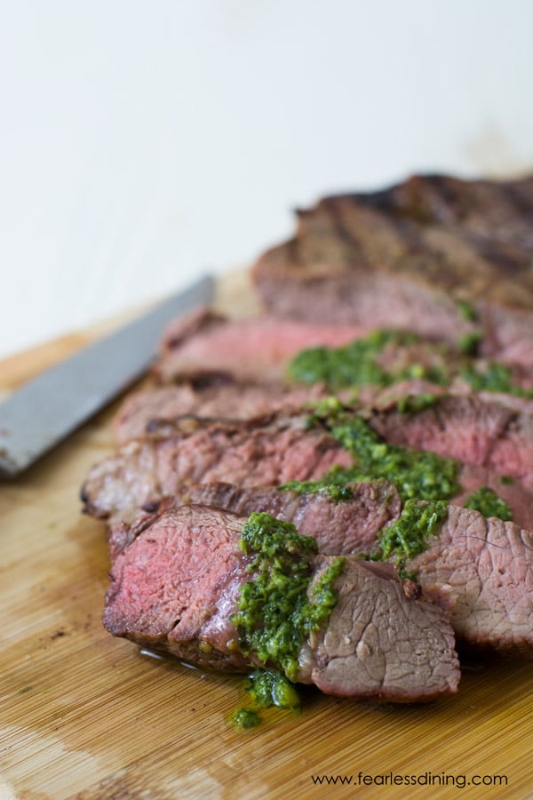 A steak with pesto sauce.