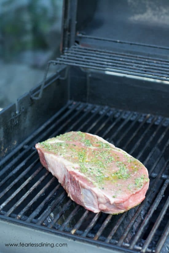 Steak with basil marinate cooking on a grill.