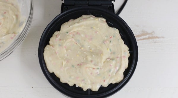 The waffle batter in a waffle iron.
