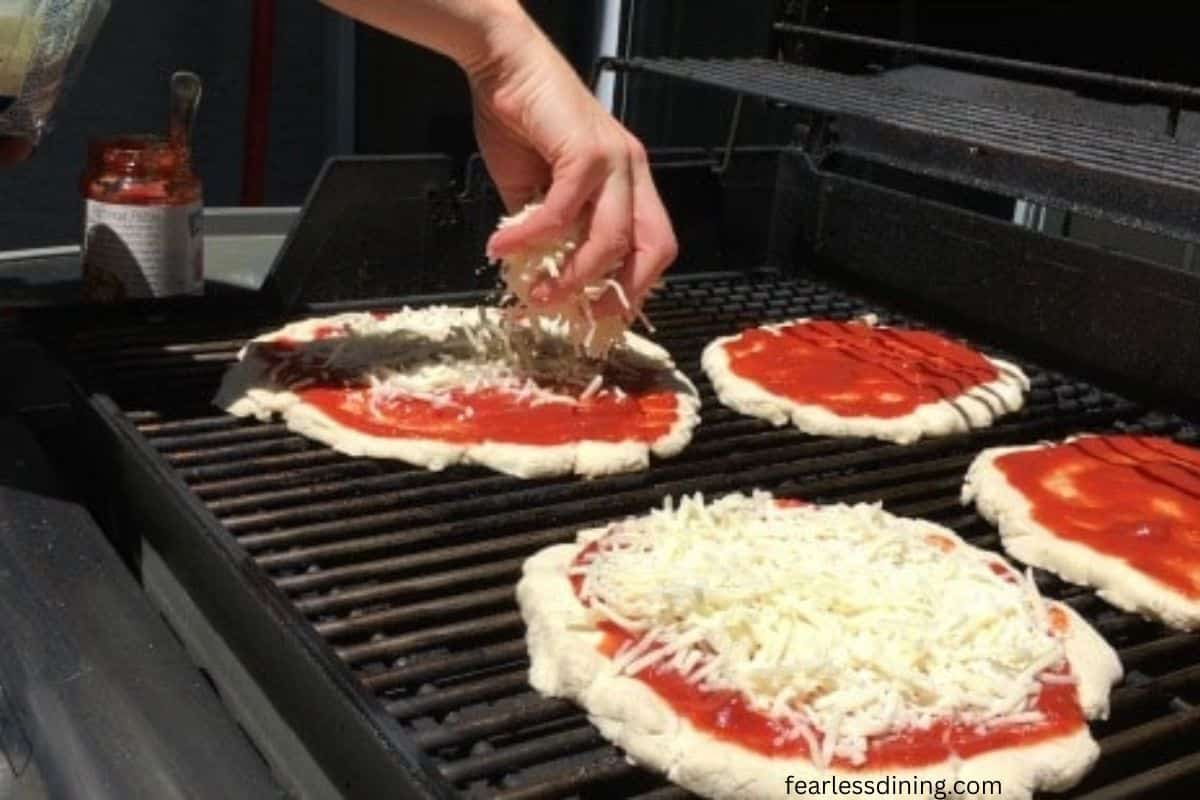 A photo showing the pizzas on the grill.