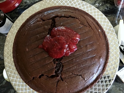 Adding layers of raspberry jam to the cake.