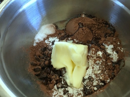 Vanilla, butter, cocoa, sugar, flour, and chocolate chips in a mixing bowl.