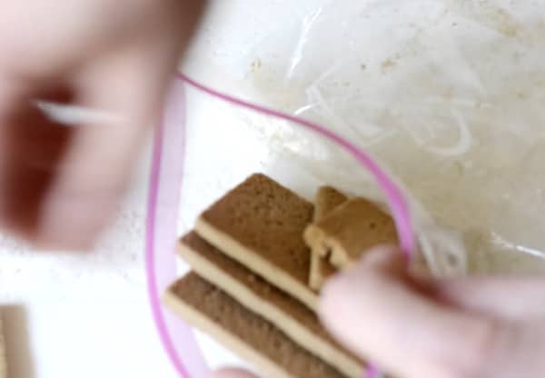 Adding gluten free graham crackers to a bag.