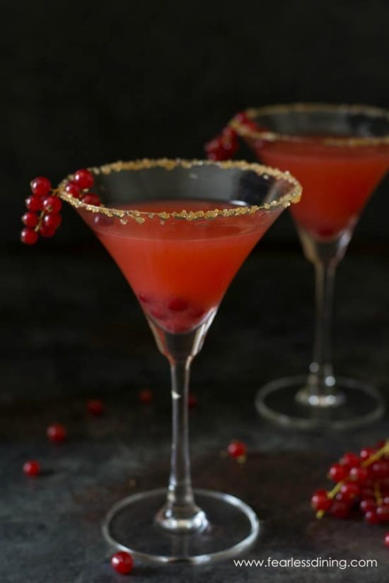 a tall martini glass filled with bright red currant margarita