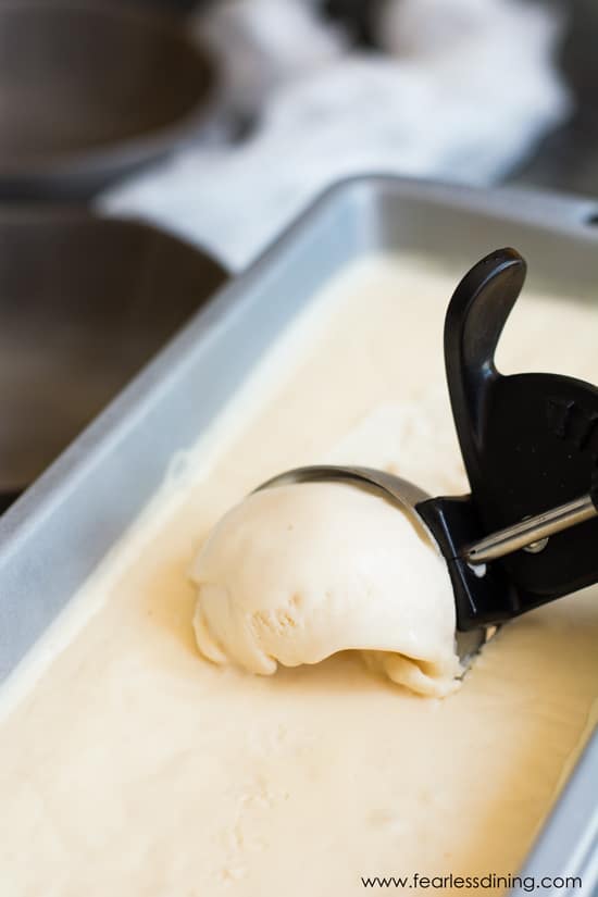 Scooping Earl Grey ice cream from a container.