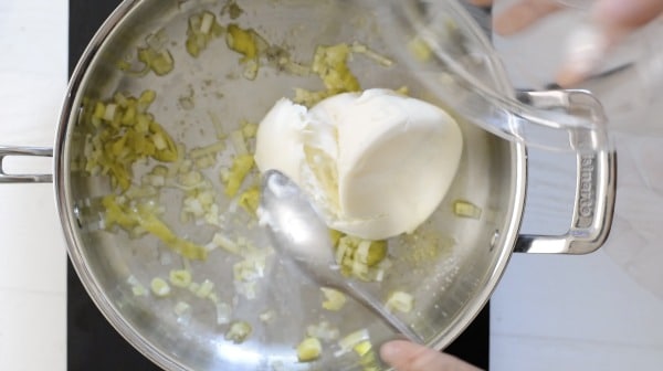 Adding ricotta to the pan.