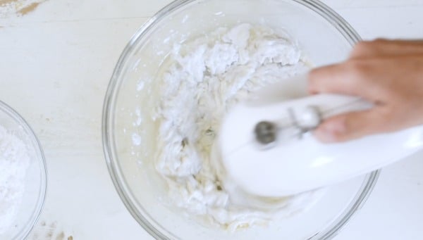 Using a mixer to mix cream cheese.