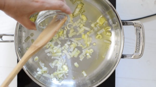 Sauteing garlic with leeks in a pan.