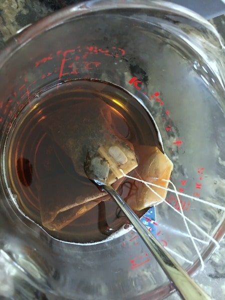 Steeping tea bags in hot water.