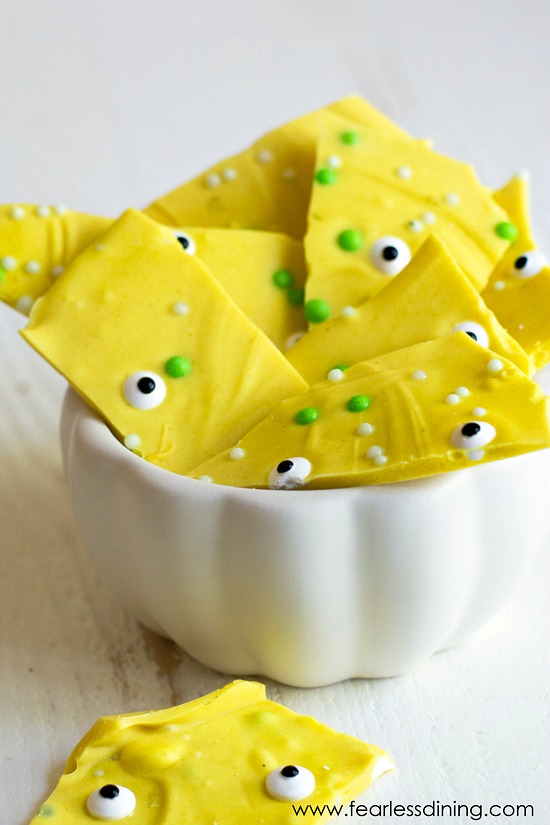 Pieces of turmeric candy overflowing a white candy dish.