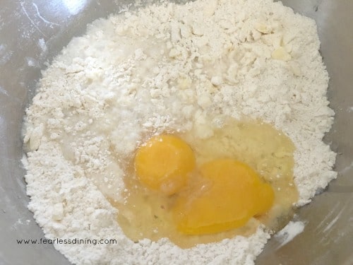A photo of eggs in the pie crust ingredients. It is ready to be mixed.