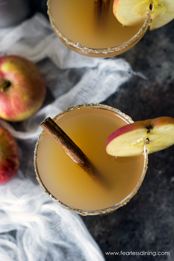 The top view of two apple cider cocktails. The glasses are garnished with apple slices.
