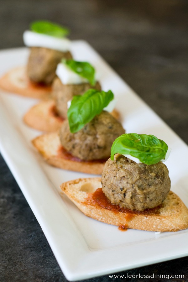 Crostini topped with marinara, a meatball, mozzarella and fresh basil.