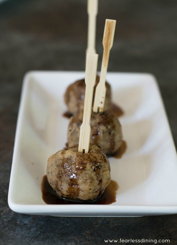 Meatballs with tooth picks on a plate.
