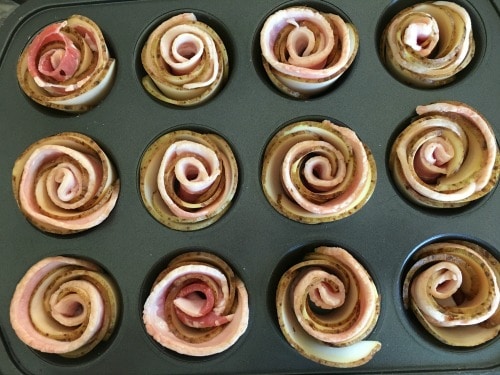 A muffin tin filled with unbaked potato bacon roses