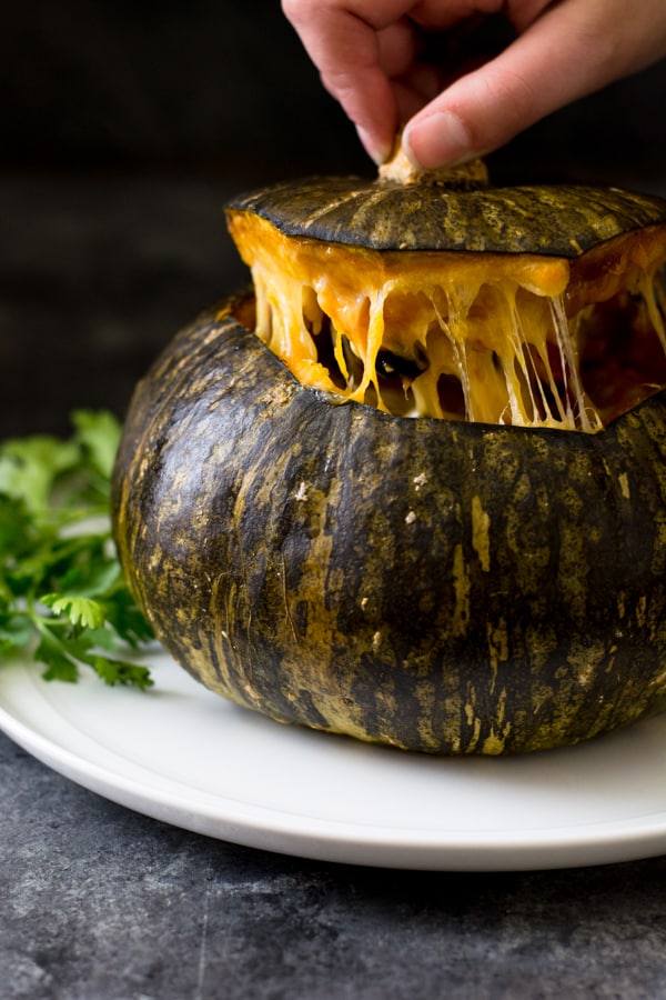 Pulling the top off a stuffed roasted kabocha squash.