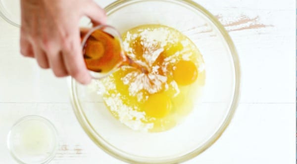 Adding wet ingredients to a mixing bowl.