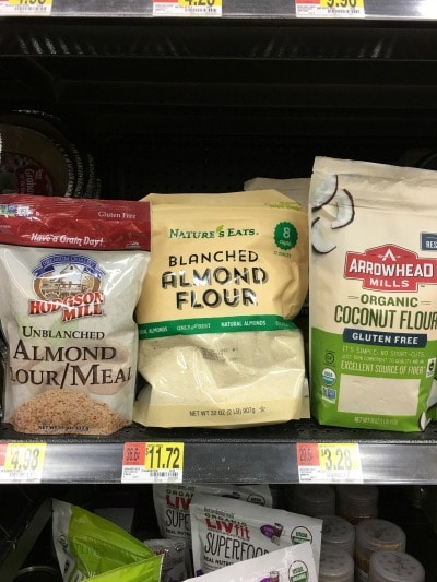 Bags of almond flour and coconut flour on a store shelf.