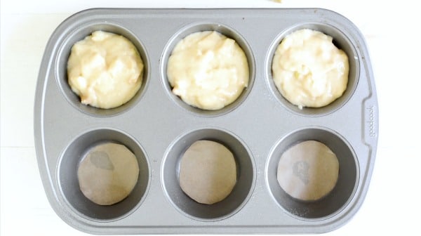A baking pan with apple cake batter in each cup.