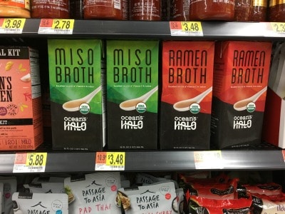 Containers of miso broth on a store shelf.