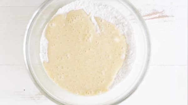 A bowl with the wet ingredients poured into the dry ingredients.