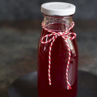 A jar of cactus pear syrup with a bow around it.