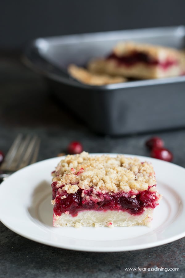 A slice of cranberry shortbread bar on a small white plate.